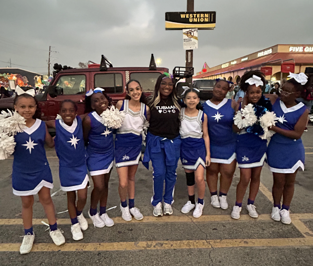 Crescent city schools cheer team posing together with their coach
